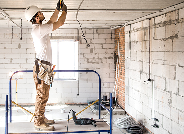 Electrician installing light fitting